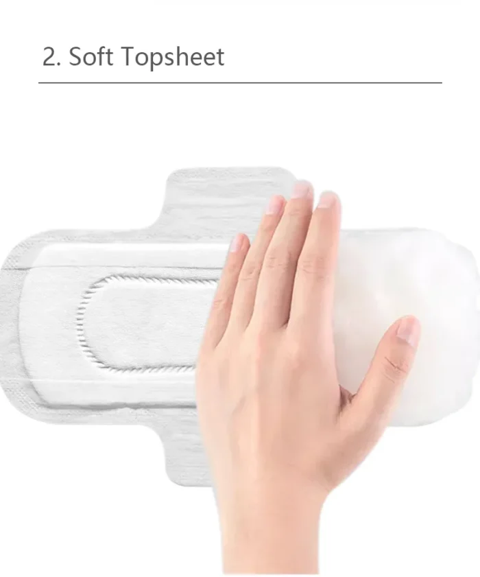 Hinahawakan ng kamay ang isang soft-topsheet daytime pad na may text 2. Soft Topsheet sa itaas.