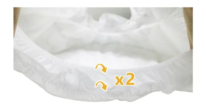 Primer plano de un pañal blanco con cinta lateral elástica y protectores dobles contra fugas.