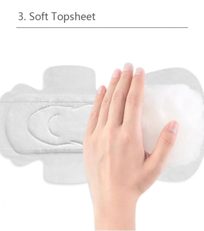 Hinahawakan ng kamay ang malambot na topsheet ng sanitary pad sa gabi.