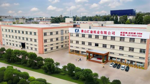 Vista aérea de la fábrica de pañales Huikang, un gran edificio industrial con un cartel en chino.