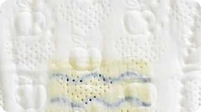 Close-up ng mga sanitary napkin na may mga embossed na mansanas at isang dilaw at asul na kulot na pattern.